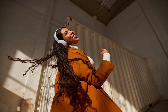 Stylish woman in headphones listening to music