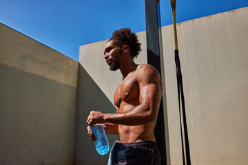 Black athlete drinking water after workout