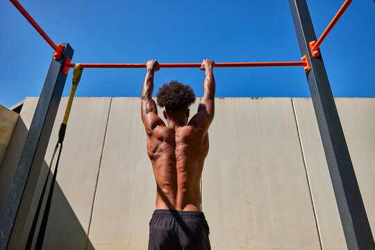 Strong man doing pull ups on bar