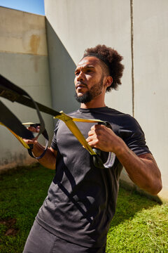 Black man exercising with TRX straps