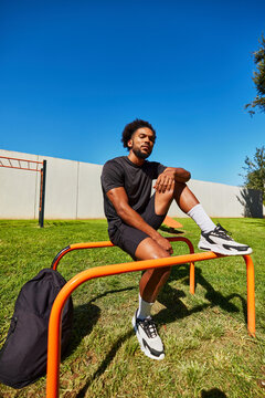 Black man resting on parallel bars