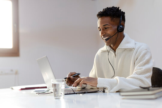 Customer service agent in call center attending call using headset