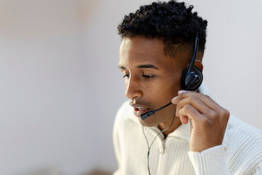 Customer service agent in call center attending call using headset.