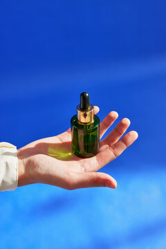 Crop hand of woman with serum bottle