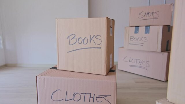 A stack of boxes with the words books and clothes written on them. New house concept.