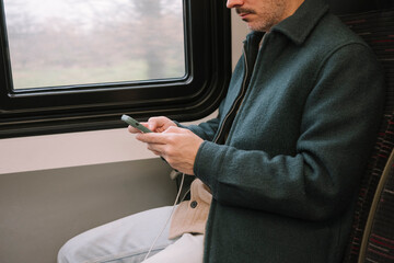 Man using the phone on the train seat