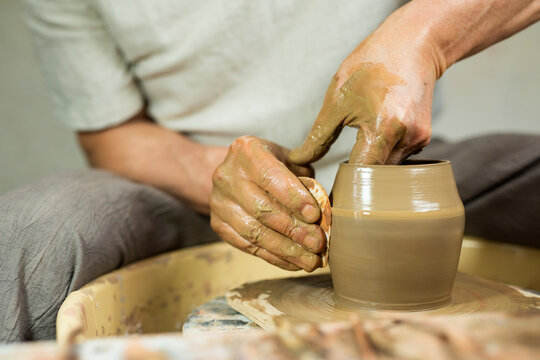 Hands of a potter creating pottery