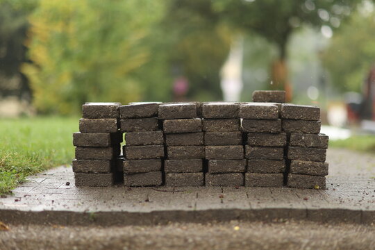 Pile of bricks is sitting on a sidewalk
