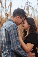 Fototapeta premium Young couple in the countryside bumping their foreheads with their eyes closed