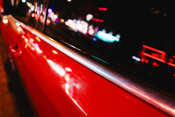 Red Car Surface with Neon Reflections at Night
