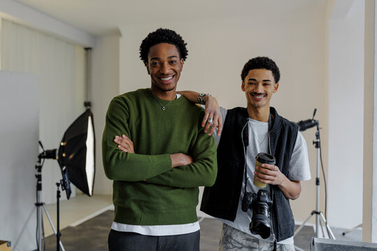 Two photographers smiling in photo studio - Powered by Adobe