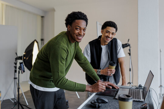 Two photographers retouching photos in modern studio