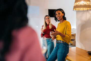 Smiling woman holding wine glass in the kitchen