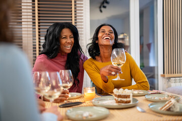 Women friends having fun together in a dinner home