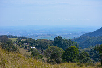 Naklejka premium Panoramic view of Serra da Paulista in Águas da Prata, São Paulo. Rolling green hills, scenic landscape, clear sky, and lush vegetation captured from a high vantage point.