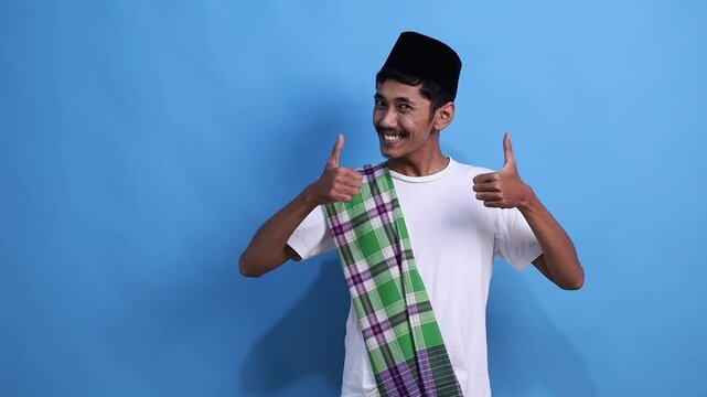 Asian muslim man smiling and holding out hand with palm up to copy space