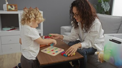 Woman and child playing toys in cozy living room, showcasing maternal bond, learning, development, education, activity, indoors, pleasant, cozy, interaction.