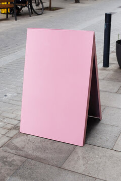 Minimal pink advertising sign on a street in urban city environment