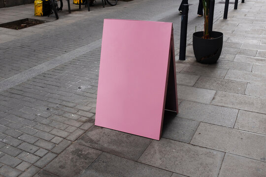 Minimal pink advertising sign on a street in urban city environment
