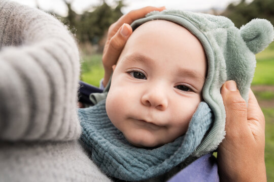 portrait of a baby whose mother puts a hat on.
