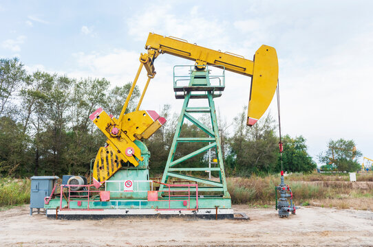 Colorful Oil Pump Jack Operating in a Natural Outdoor Setting