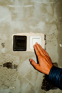 man presses a rocker switch