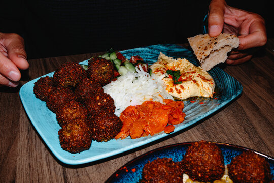 man eating a combo platter with falafel and hummus