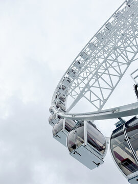 Bottom cropped view of ferris wheel with cloudy sky on background