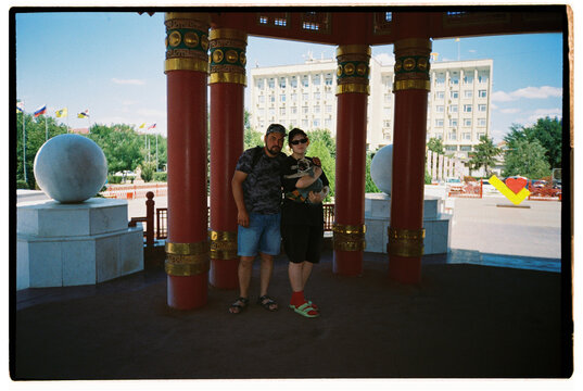 A man and a girl in a traditional pavilion in a city park 