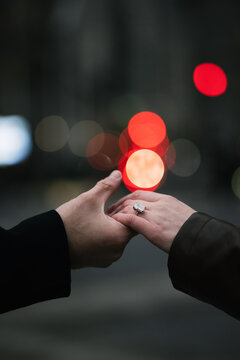 Hands Holding with Engagement Ring and City Lights