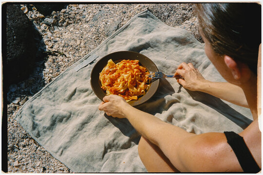 Woman enjoying a plate of pasta during an outdoor picnic in Lanzarote