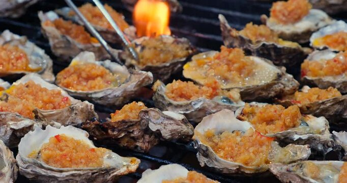 Grilled oysters with garlic. Cooking seafood on barbecue grill