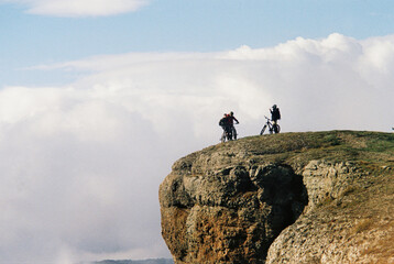 Cyclists enjoy a breathtaking view from a rocky cliff during the day