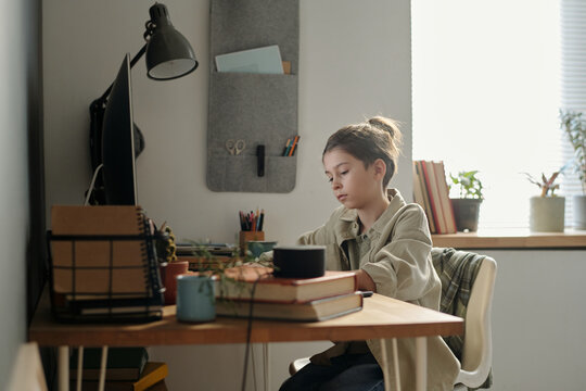 Teenager Studying at Home Desk Equipped with Gadgets