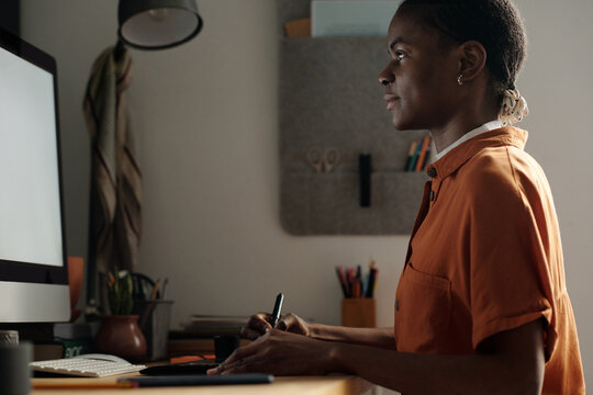 Female Graphic Designer Using Smart Devices for Work at Home Desk