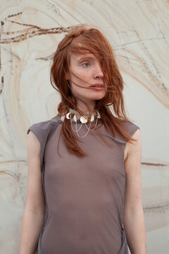 young woman with red hair in see through blouse