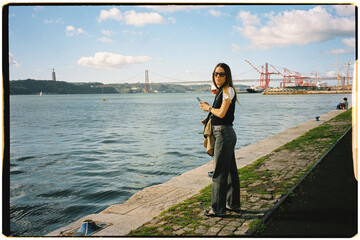 Film portrait of a female tourist posing on the Tagus River in Lisbon