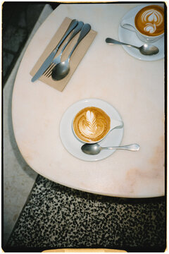 Film close up of two specialty coffee cups decorated with latte art