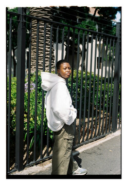 Portrait of young woman wearing white hoodie and green cargo pants