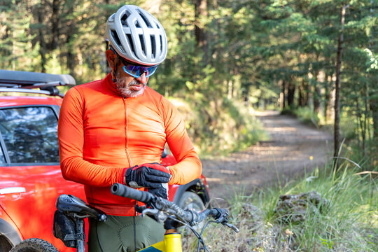 Senior cyclist prepares his smart watch to measure his biking training