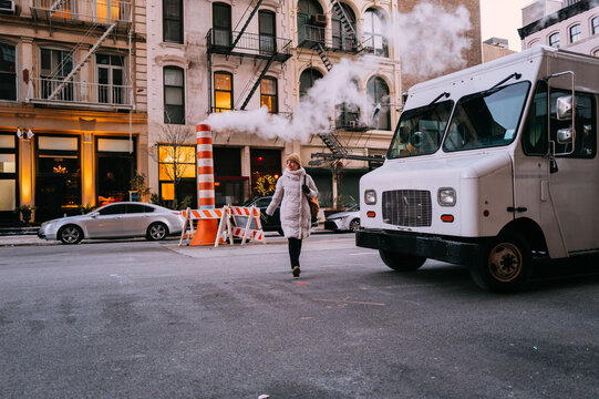 Woman Walking Near Steam Vent and Delivery Truck in Manhattan