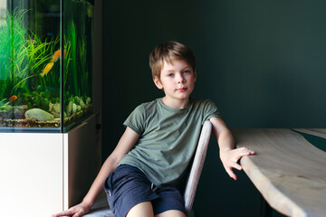 Relaxing Boy by the Aquarium in a Cozy Room
