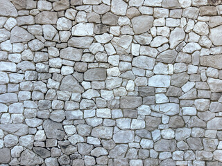 Stacked natural grey stone brick wall. Rock decoration. Exterior stone wall decorative