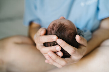 Mother holding newborn baby's head after cesarean section