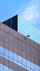 Fototapeta premium Modern Architectural Symmetry - Minimalist geometric facade with reflective blue glass, ideal for design portfolios, urban planning presentations, or architectural branding