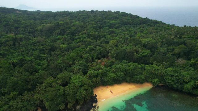 Aerial pan shot overlooking the Margarida Beach and dense jungle of Sao Tome