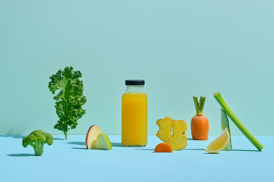 Healthy Juice Bottle Surrounded by Fresh Fruits and Vegetables on blue