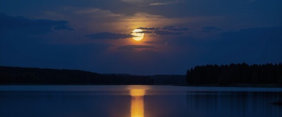 Naklejka premium A luminous moon reflects on the mirror-like waters of a forest lake, enhancing the night’s beauty.