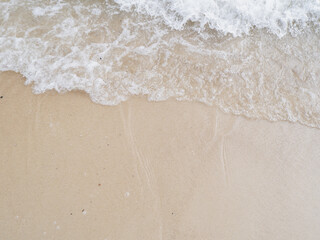background of waves and foam on beach sand. summer vacation concept