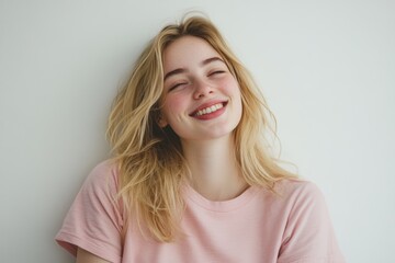 Fototapeta premium Carefree Blonde Woman Laughing in a Soft Pink Shirt Against a White Background. Generative AI.